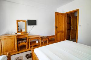 a bedroom with a bed and a desk with a mirror at Yagodina Family Hotel in Yagodina