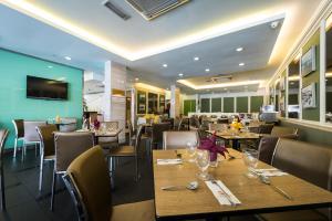 a dining room with wooden tables and chairs at Hotel Sentral Georgetown @ City Centre in George Town