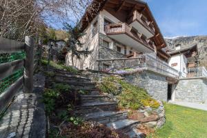 a stone house with stairs leading up to it at Residence Larice Bianco App n2 in Campodolcino