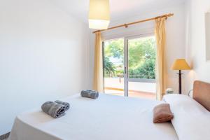 a bedroom with a bed and a large window at Mercuri in Port d'Alcudia