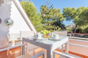 a white table and chairs on a balcony with trees at Mercuri in Port d'Alcudia +18 photos