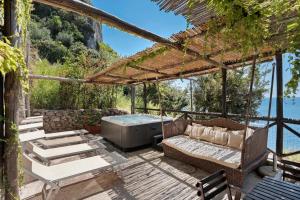 a patio with a couch and a hot tub at Luxury Villa Seaview con jacuzzi in Conca dei Marini