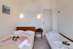 a bedroom with two beds with towels and a table at Nikiana Club - Studio 3 in Nikiana