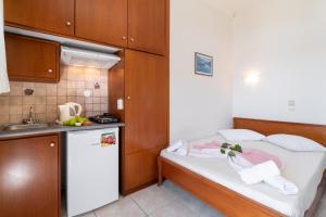 a small kitchen with a bed and a refrigerator at Nikiana Club - Studio 3 in Nikiana