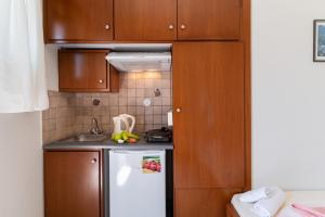 a small kitchen with wooden cabinets and a white refrigerator at Nikiana Club - Studio 3 in Nikiana