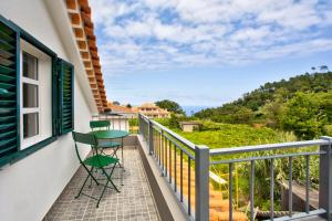 a balcony with two chairs and a table on it at Casa da Olides - Studio in Santana
