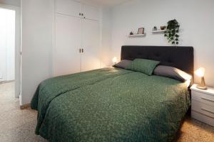 a bedroom with a bed with a green comforter at Apartamento vistas playa Torrox A73 in Torrox +24 photos