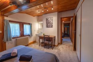 a bedroom with a bed and a desk and a table at Chalet Le Margouillat in Les Houches