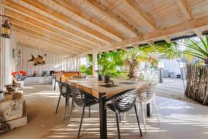 a dining room with a wooden table and chairs at Villa la forge expérience bien-être in Nuaillé-dʼAunis