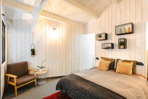 a bedroom with a bed and a chair at Villa la forge expérience bien-être in Nuaillé-dʼAunis
