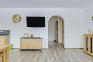 a living room with a tv on a white wall at Ferienwohnung Schachen in Garmisch-Partenkirchen