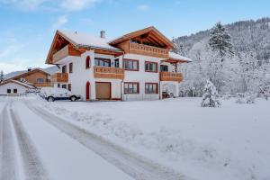 a house with a car parked in the snow at Ferienwohnung Schachen in Garmisch-Partenkirchen