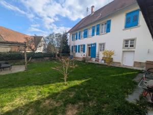 a house with blue windows and a yard at Ferienwohnung Altes Pfarrhaus in Blumberg