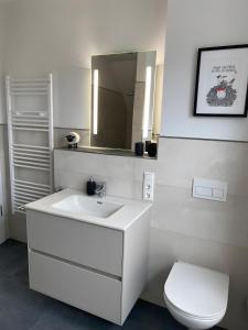 a bathroom with a white sink and a toilet at Ferienhaus Strandnest Dangast in Dangast +22 photos