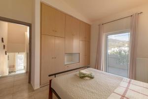 a bedroom with a bed and a large window at Villa Melenia 2 in Agia Pelagia