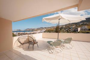 a balcony with a table and chairs and an umbrella at Villa Melenia 2 in Agia Pelagia