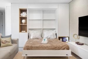 a bedroom with a large bed and a couch at Apulia Apartment in Apúlia