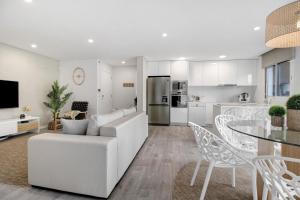 a living room and kitchen with a couch and a table at Apulia Apartment in Apúlia +12 photos