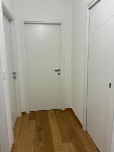 an empty room with a white door and wooden floors at Biancamilla's Home in Giulianova +2 photos