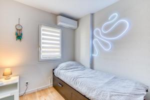 a small bedroom with a bed and a window at Le Mas de la Mer in Frontignan