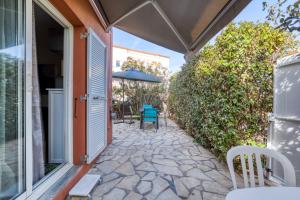 a patio with an umbrella and a table and chairs at Le Mas de la Mer in Frontignan