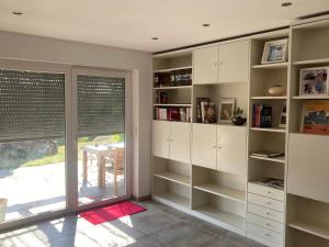 a room with white cabinets and a large window at Draußen am See in Losheim