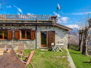 a small stone house with a table and chairs at Chalet Baita Santina by Interhome in Peglio
