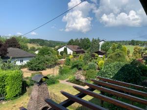 a group of wooden benches sitting in a garden at Draußen am See in Losheim