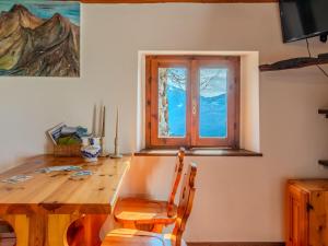 a dining room with a wooden table and a window at Chalet Baita Santina by Interhome in Peglio