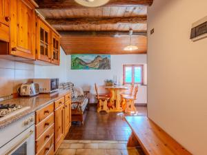 a kitchen with wooden cabinets and a table in a room at Chalet Baita Santina by Interhome in Peglio