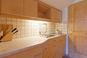 a kitchen with wooden cabinets and a sink at Bruneggerhof Weissenbach in Rio Bianco +56 photos