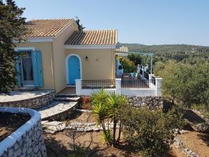 a small house with a blue door and stairs at Villa Ostria in Tsoukalades