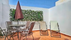 a table and chairs and an umbrella in a room at Apartamento Galoponte - Laaldeabnb in San Nicolás