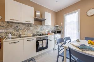 a kitchen with white cabinets and a table with a counter top at La Terrazza Di Porticello in Porticello