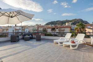 a rooftop patio with chairs and an umbrella at La Terrazza Di Porticello in Porticello