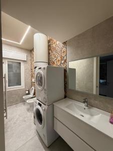 a bathroom with a washing machine and a sink at Valepiace 1 in Piacenza