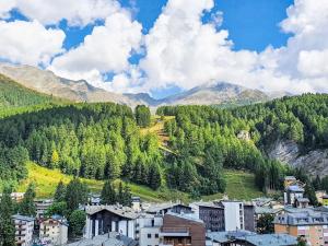 a town in the mountains with trees and buildings at Apartment La Marmotta by Interhome in Madesimo