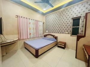 a small bedroom with a bed and a sink at Hotel Shiv-Shakti in Solapur