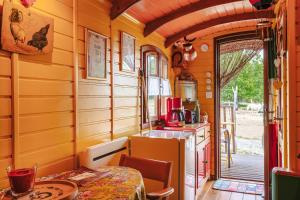 a small kitchen with a table and a table and chairs at Roulotte la casetta Rita in Chambon