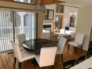 a dining room and living room with a table and chairs at Contemporary & Spacious South Cape Beach House in Mashpee