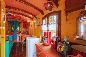 a kitchen with yellow walls and a white refrigerator at Roulotte la casetta Rita in Chambon +12 photos