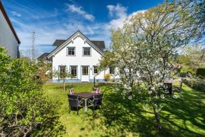 a white house with a table in the yard at Ferienwohnung 2 in Groß Zicker