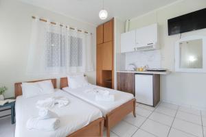 two beds in a room with a kitchen at S7 apartment in Nikiana
