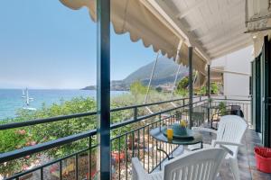 a balcony with a table and chairs overlooking the ocean at S7 apartment in Nikiana
