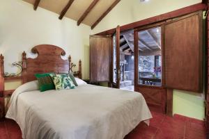 a bedroom with a large bed and a window at Finca el pilar in La Guancha +32 photos