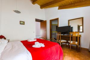 a bedroom with a bed with a red blanket and a desk at Ospitalità D'alunzio in San Marco dʼAlunzio