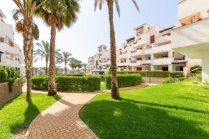 a walkway with palm trees in front of a building at Apartamento increible Playazo Vera in Vera