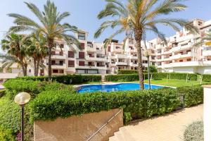 a large apartment building with a swimming pool and palm trees at Apartamento increible Playazo Vera in Vera