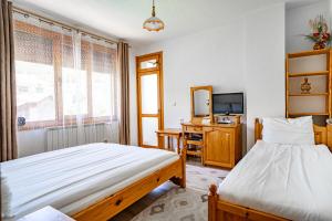 a bedroom with two beds and a television in it at Yagodina Family Hotel in Yagodina