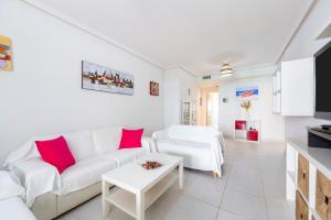a living room with a white couch and red pillows at Apartamento increible Playazo Vera in Vera